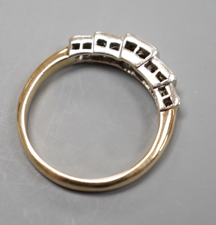 A yellow metal and graduated illusion set five stone diamond half hoop ring, size M/N, gross weight 3.2 grams.